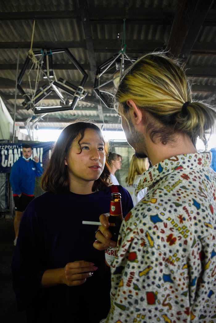 A candid indoor photo showing a group of young adults at a social event, engaging with drinks.